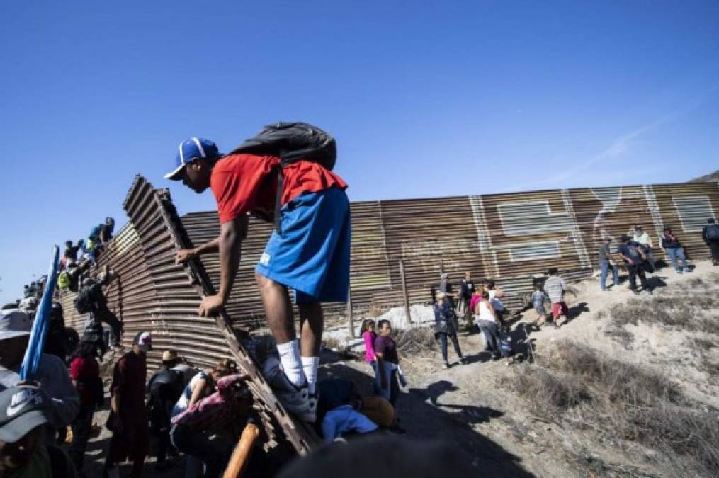 Cientos de migrantes tratan de saltar la valla fronteriza entre México y EEUU