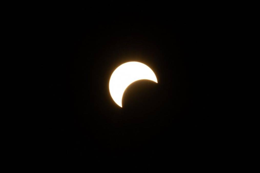 <i>La luna cruza frente al sol durante el eclipse solar anular en Caracas, el 14 de octubre de 2023. Los observadores del cielo de todo el continente americano volvieron sus rostros hacia arriba el sábado para presenciar un raro evento celeste: un eclipse solar anular. (Foto de Federico PARRA/AFP)</i>