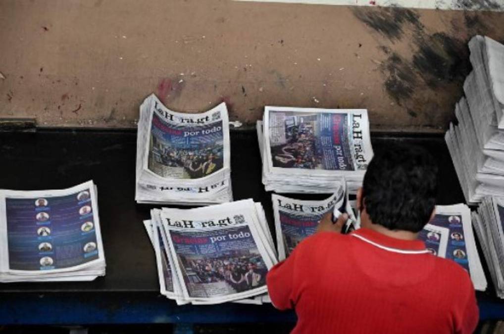 A worker arranges the last print edition of the newspaper La Hora in Guatemala City on November 12, 2021. - After 101 years, the evening newspaper La Hora de Guatemala printed its last paper edition on Friday, amid the nostalgia of workers and readers. As of Saturday, only an online edition will be avilable. (Photo by Johan ORDONEZ / AFP)