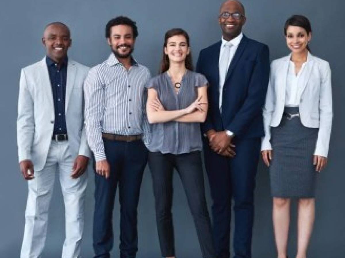 Studio shot of corporate businesspeople posing against a gray background