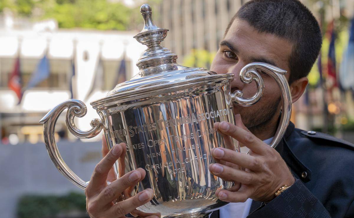 <i>El tenista español Carlos Alcaraz, besa el trofeo que lo acredita como campeón del Abierto de Estados Unidos 2025 este lunes, en el Rockefeller Center de Nueva York (EE.UU.). Alcaraz ha superado los 53 millones de dólares (45 millones de euros, aproximadamente) en premios una vez sumados los cinco que se embolsó por su triunfo el domingo en el Abierto de los Estados Unidos. EFE/Ángel Colmenares</i>