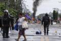 <i>Civiles y policías fueron captados este domingo, 22 de junio, en una calle bloqueada durante una nueva jornada de protestas, en Changuinola (Bocas del Toro, Panamá). EFE/Bienvenido Velasco</i>