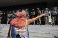 <i>Un mujer fue capada este martes, 10 de junio, al increpar a miembros de la Guardia Nacional de California que custodian la entrada del edificio federal, durante las protestas contra su presencia y las redadas a migrantes presuntamente indocumentados, en Los Ángeles (CA, EEUU). EFE/Allison Dinner</i>