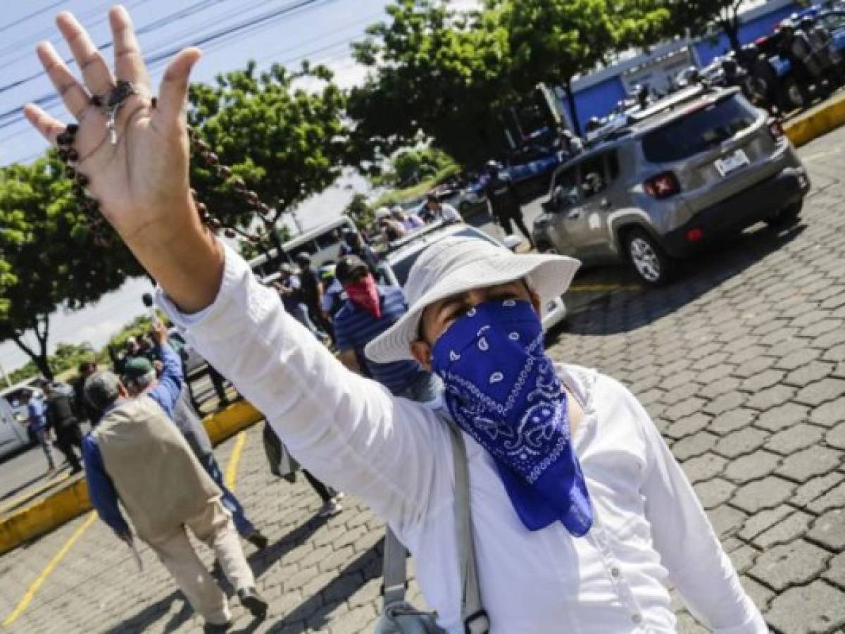 Un manifestante muestra su rosario en una protesta contra el presidente de Nicaragua, Daniel Ortega, en Managua, Nicaragua. (Photo by INTI OCON / AFP)