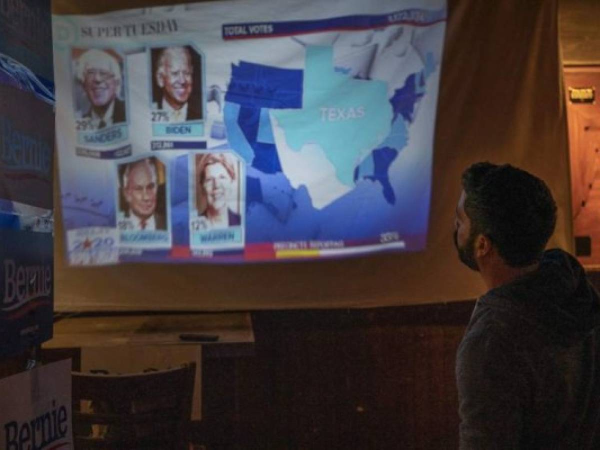A Bernie Sanders supporter watches the election results come in at the Hoppy Monk bar in El Paso, Texas on March 3, 2020, Super Tuesday. - Fourteen states and American Samoa are holding presidential primary elections, with over 1400 delegates at stake. Americans vote Tuesday in primaries that play a major role in who will challenge Donald Trump for the presidency, a day after key endorsements dramatically boosted Joe Biden's hopes against surging leftist Bernie Sanders. The backing of Biden by three of his ex-rivals marked an unprecedented turn in a fractured, often bitter campaign. (Photo by Paul Ratje / AFP)
