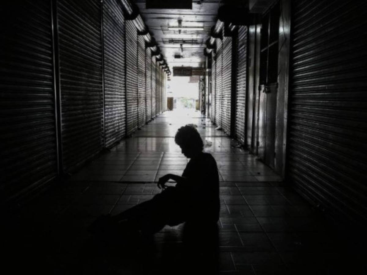 A homeless person sleeps outside shops in the 'Roberto Huembes' market that are closed during a 24-hour nationwide general strike called by the opposition in Nicaragua, in Managua on June 14, 2018.A general strike was declared Thursday in Nicaragua to protest the government's deadly crackdown on a two-month long popular uprising against President Daniel Ortega, hours after the Catholic Church moved towards rekindling talks to calm the crisis that rights groups say has killed at least 157 people. / AFP PHOTO / INTI OCON