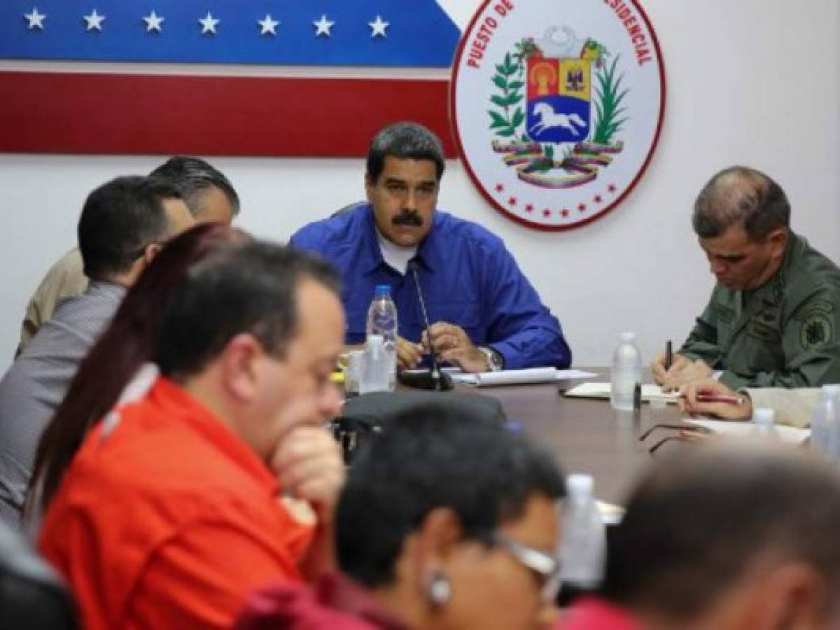 Venezuelan President Nicolas Maduro (C) speaks with his ministers during meeting in Caracas on July 17, 2017. US President Donald Trump threatened Venezuela with swift 'economic actions' on Monday if its leader, Nicolas Maduro, pushes on with an unpopular bid to change his country's constitution in the teeth of mounting condemnation. / AFP PHOTO / JUAN BARRETO