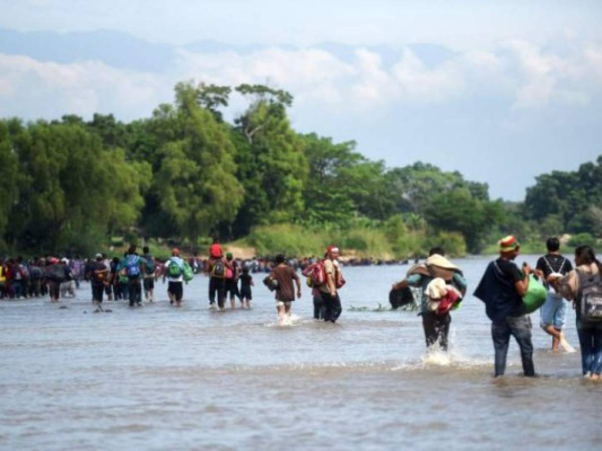 Migrants cross the Suchiate River from Tecun Uman in Guatemala to Ciudad Hidalgo in Mexico, after a security fence on the international bridge was reinforced to prevent them from passing through, on October 29, 2018. - A new group of Honduran migrants is trying to reach and cross the Guatemalan border into Mexico in the hope of eventually realizing the 'American dream' and reaching the United States. (Photo by Johan ORDONEZ / AFP)