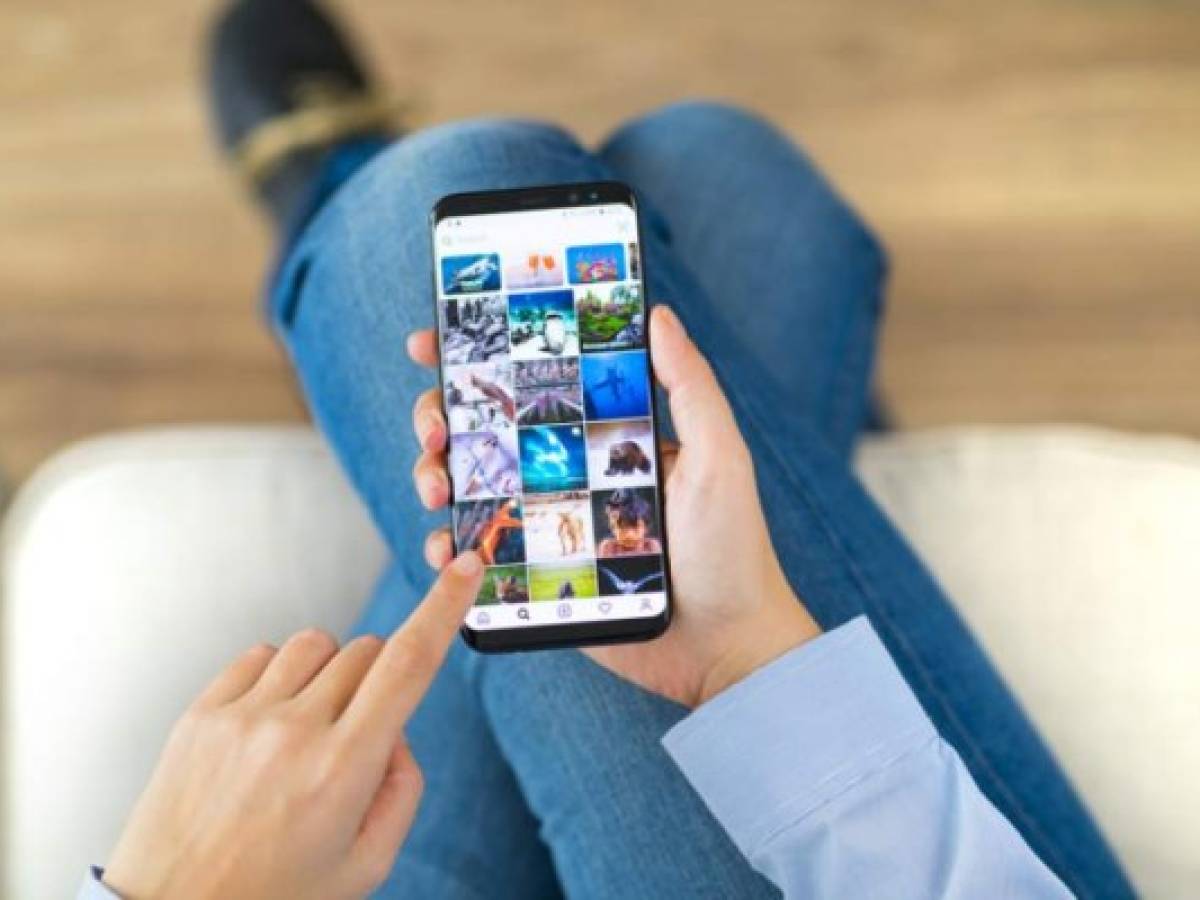 Ä°stanbul, Turkey - February 10, 2019: Woman using smart phone on a couch. The smart phone is an iPhone 8 displaying Instagram application. iPhone is a touchscreen smartphone developed by Apple Inc.