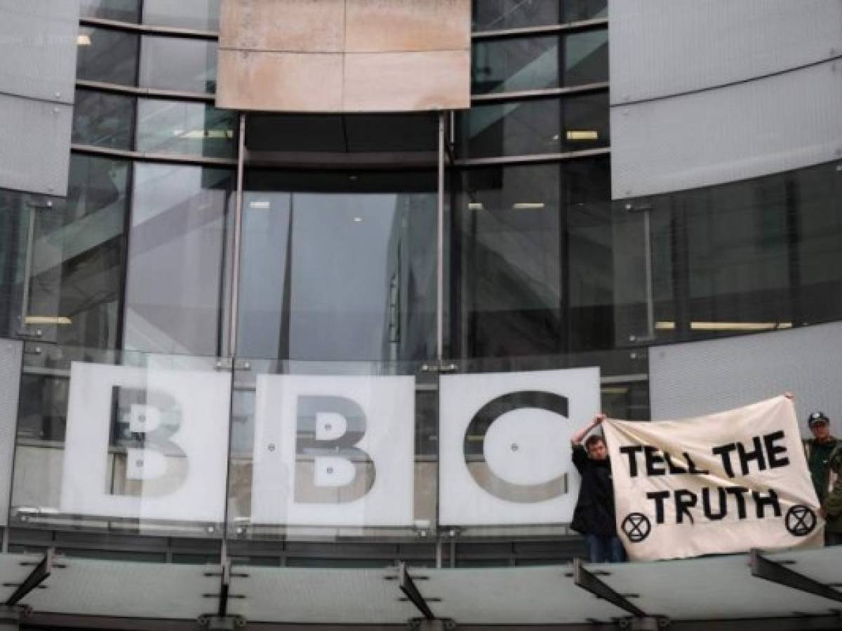 Climate activists hold a banner after climbing up to the BBC sign during a protest action at the BBC offices during the fifth day of demonstrations by the climate change action group Extinction Rebellion, in London, on October 11, 2019. - London police have reported making more than 1,000 arrests over four days of protests by the group Extinction Rebellion, which have been staging a global effort stretching from Sydney to New York. (Photo by DANIEL LEAL-OLIVAS / AFP)