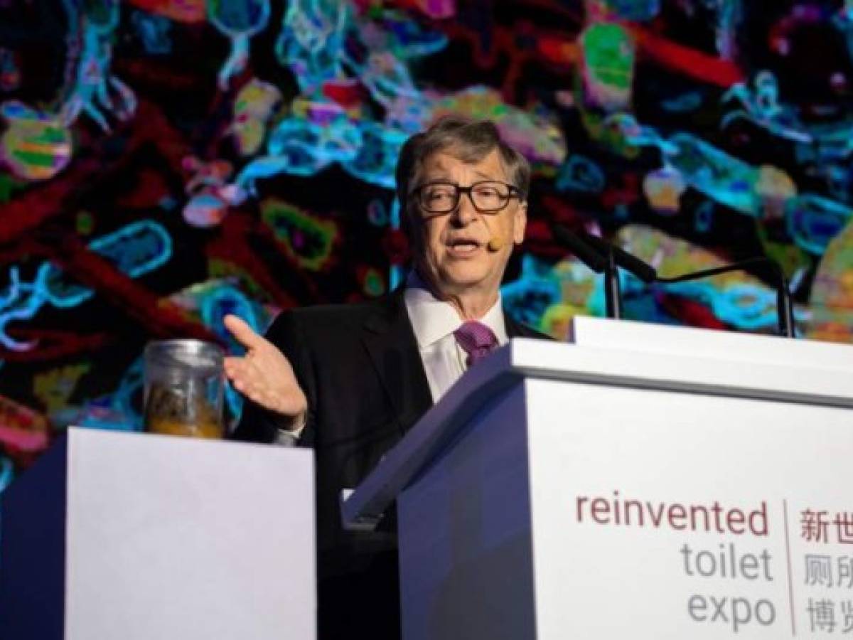 Microsoft founder Bill Gates (R) talks next to a container (L) with human feces during the 'reinvented toilet expo' in Beijing on November 6, 2018. (Photo by Nicolas ASFOURI / AFP)