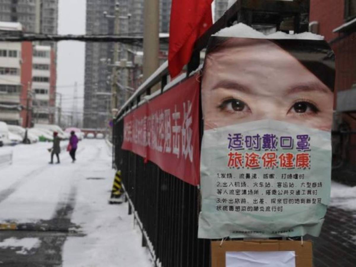 A poster advising about measures to protect from the coronavirus is seen at the entrance to a residential compound in Beijing on February 6, 2020. - The number of confirmed infections in China's coronavirus outbreak has reached 28,018 nationwide with 3,694 new cases reported, the National Health Commission said on February 6. (Photo by GREG BAKER / AFP)