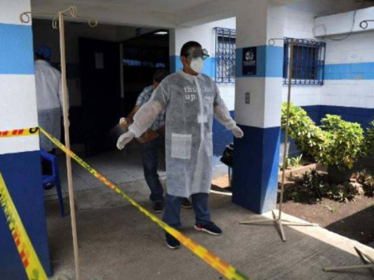 A man is disinfected by a health worker at sports dorms used to house Guatemalan citizens who are deported from the U.S. in Guatemala City on May 14, 2020. (Photo by Johan ORDONEZ / AFP)