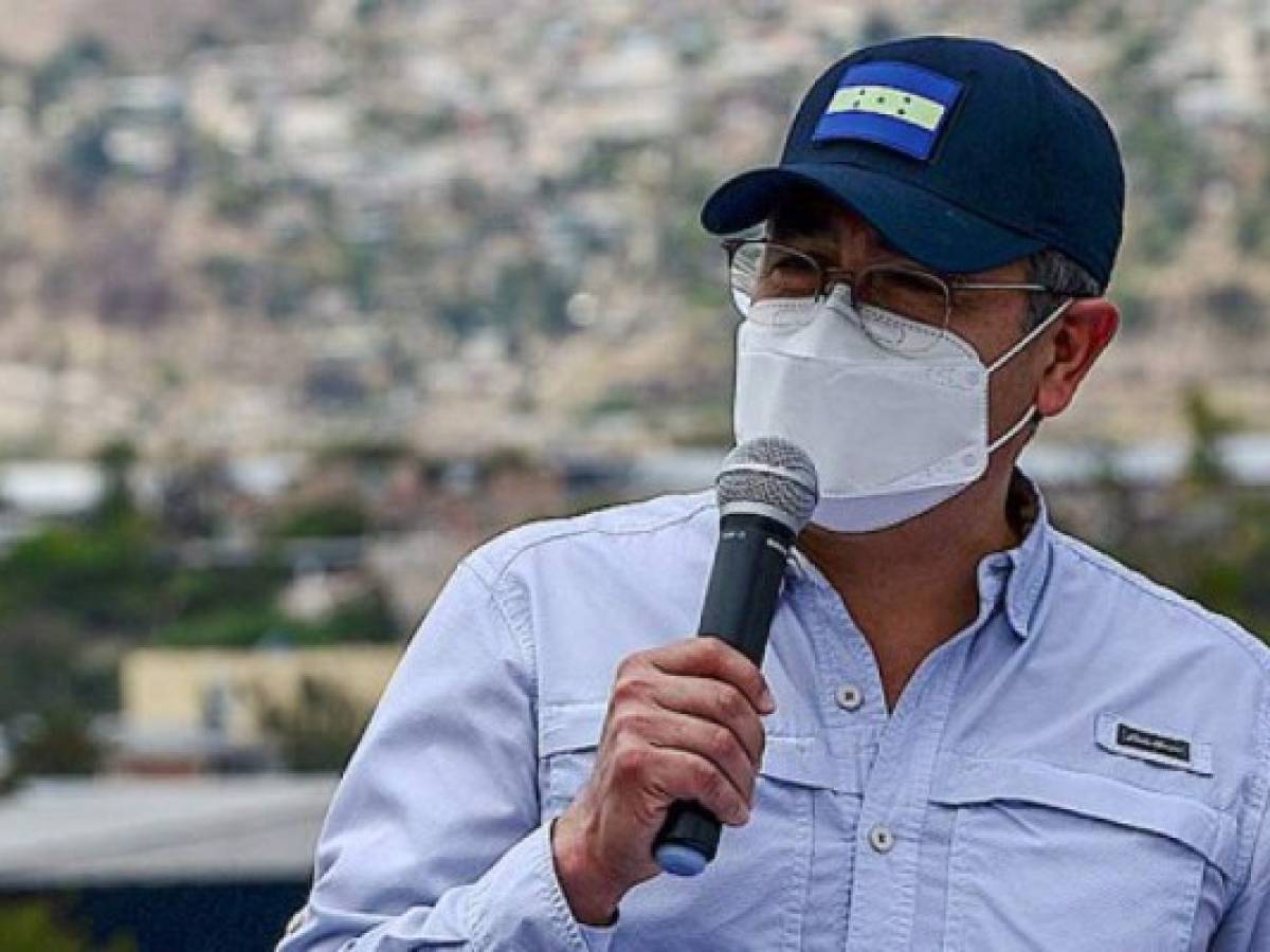 Honduras' President Juan Orlando Hernandez speaks upont the arrival of the first shipment of 48,000 doses of the Oxford-AstraZeneca vaccine provided by the COVAX mechanism at Hernan Acosta Mejia Air Base in Tegucigalpa, on March 13, 2021. (Photo by Orlando SIERRA / AFP)