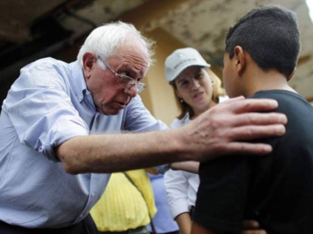 US Sen. Bernie Sanders (I- VT) talks to a child resident of the Playita community during a visit with the Mayor of San Juan, Carmen Yulin Cruz in San Juan, Puerto Rico, on October 27, 2017.More than 73,000 people have fled emergency conditions at home for Florida since Hurricane Maria devastated the US territory in the Caribbean. / AFP PHOTO / Ricardo ARDUENGO