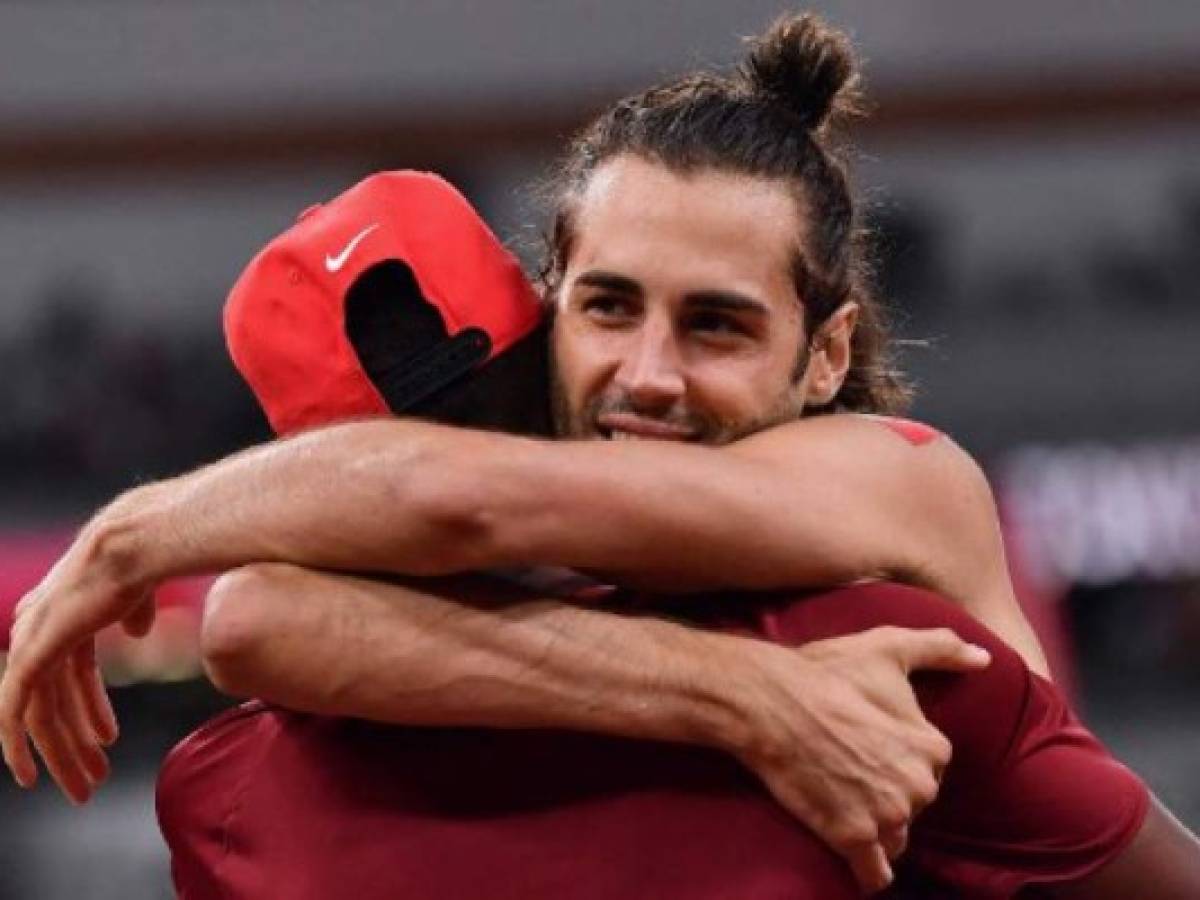 Gold medallists Italy's Gianmarco Tamberi (R) and Qatar's Mutaz Essa Barshim celebrate after the men's high jump final during the Tokyo 2020 Olympic Games at the Olympic Stadium in Tokyo on August 1, 2021. (Photo by Ben STANSALL / AFP) / The erroneous mention[s] appearing in the metadata of this photo by Ben STANSALL has been modified in AFP systems in the following manner: [Gold medallists] instead of [---]. Please immediately remove the erroneous mention[s] from all your online services and delete it (them) from your servers. If you have been authorized by AFP to distribute it (them) to third parties, please ensure that the same actions are carried out by them. Failure to promptly comply with these instructions will entail liability on your part for any continued or post notification usage. Therefore we thank you very much for all your attention and prompt action. We are sorry for the inconvenience this notification may cause and remain at your disposal for any further information you may require.