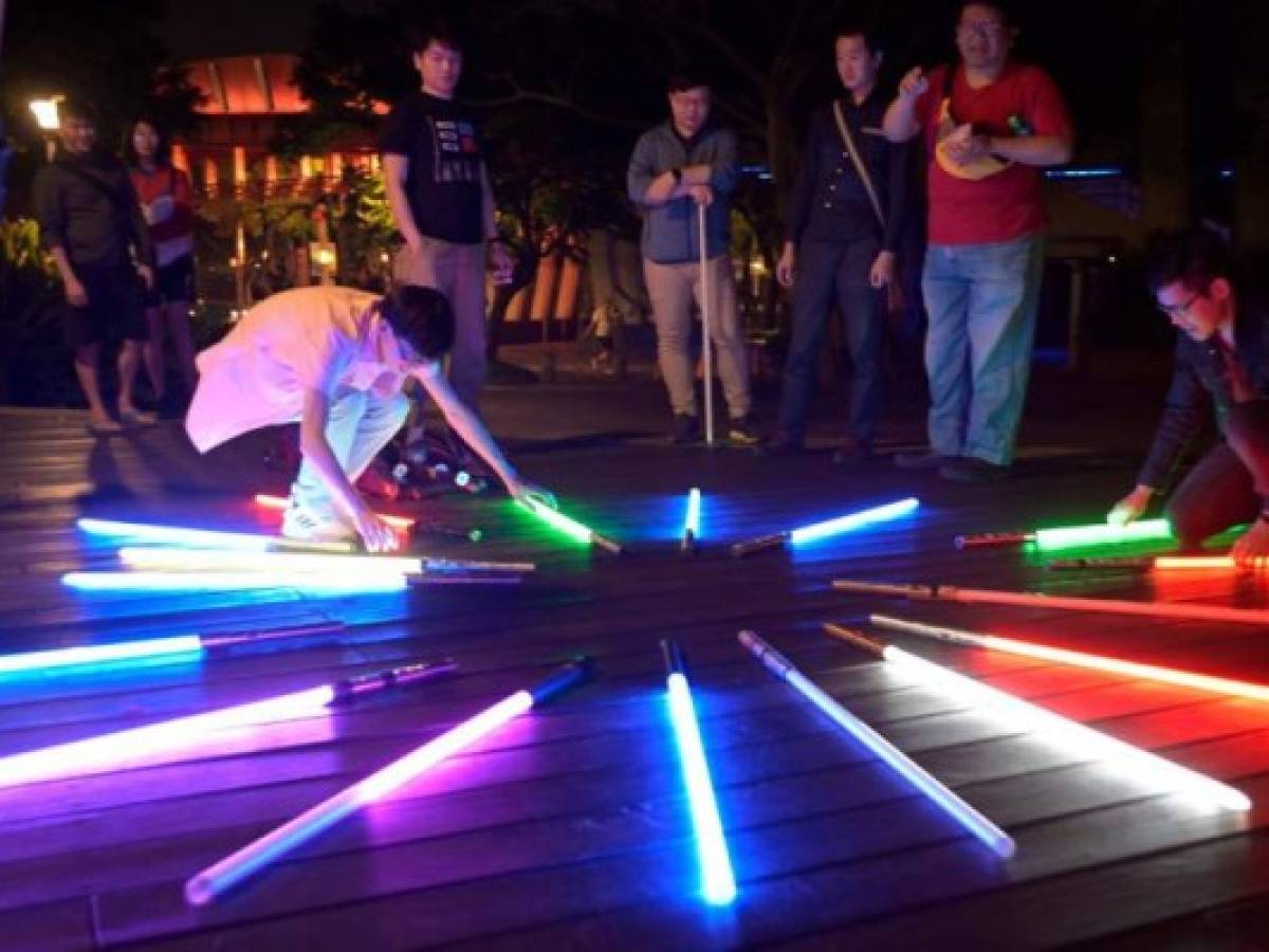 This picture taken on April 20, 2019 shows fans arranging model lightsabers during an event to promote the upcoming unofficial Star Wars Day in Taipei. - Frustrated by the lack of quality lightsabers in toy shops, Makoto Tsai did what any self-respecting hardcore Star Wars fan would do -- he studied engineering at college and then spent years perfecting a replica. (Photo by Sam YEH / AFP) / To go with AFP story 'Taiwan culture movie StarWars', FEATURE by Amber Wang