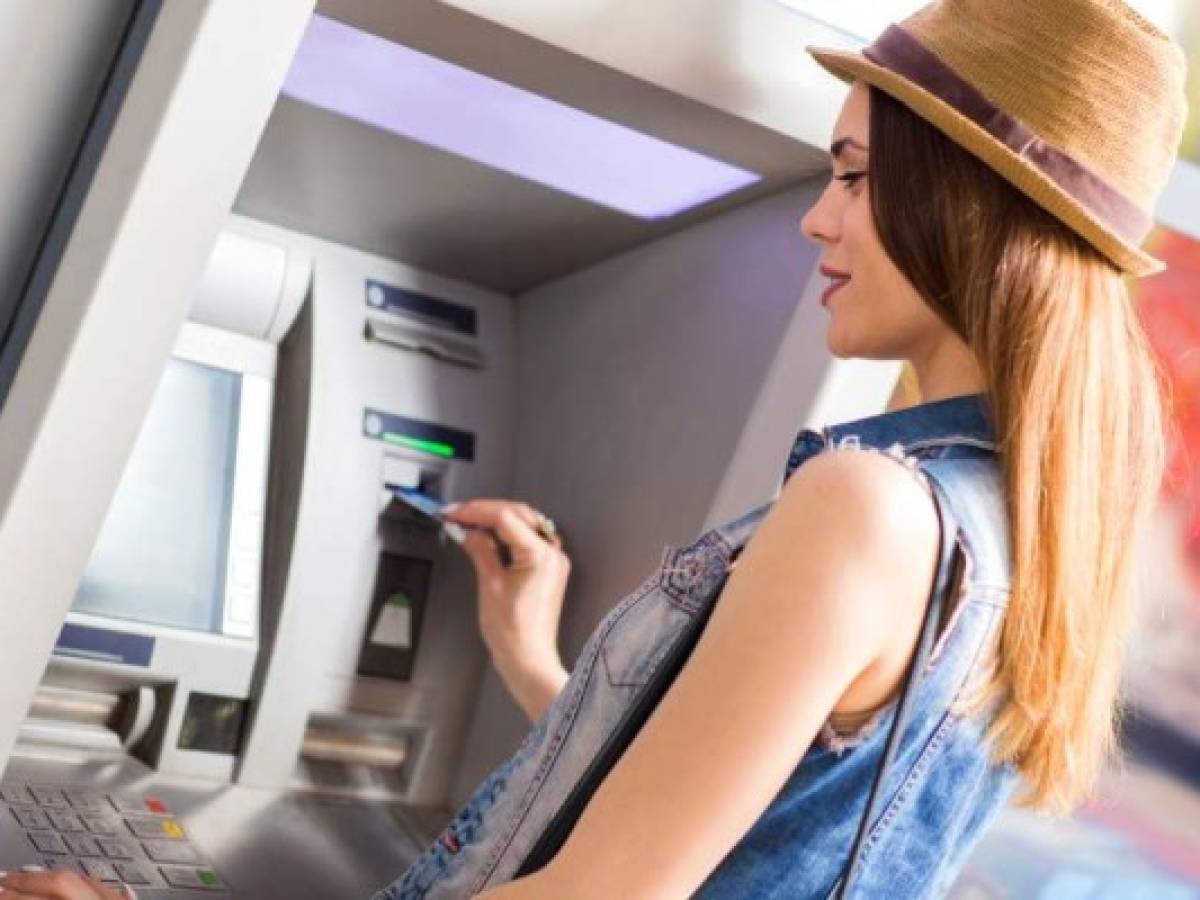 Young woman withdrawing money at the ATM.