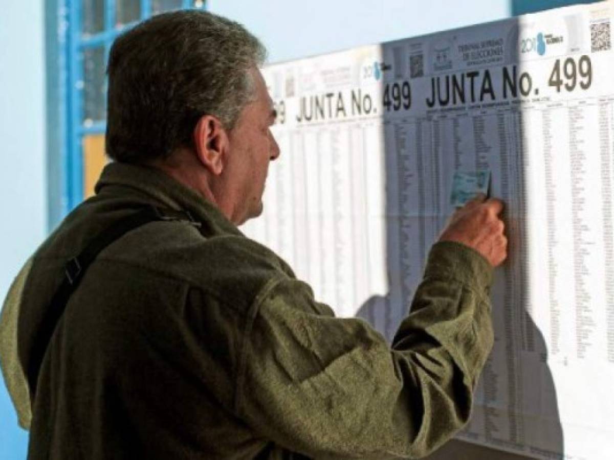 Un votante busca su nombre en la lista electora en San José. AFP PHOTO / Jorge RENDON