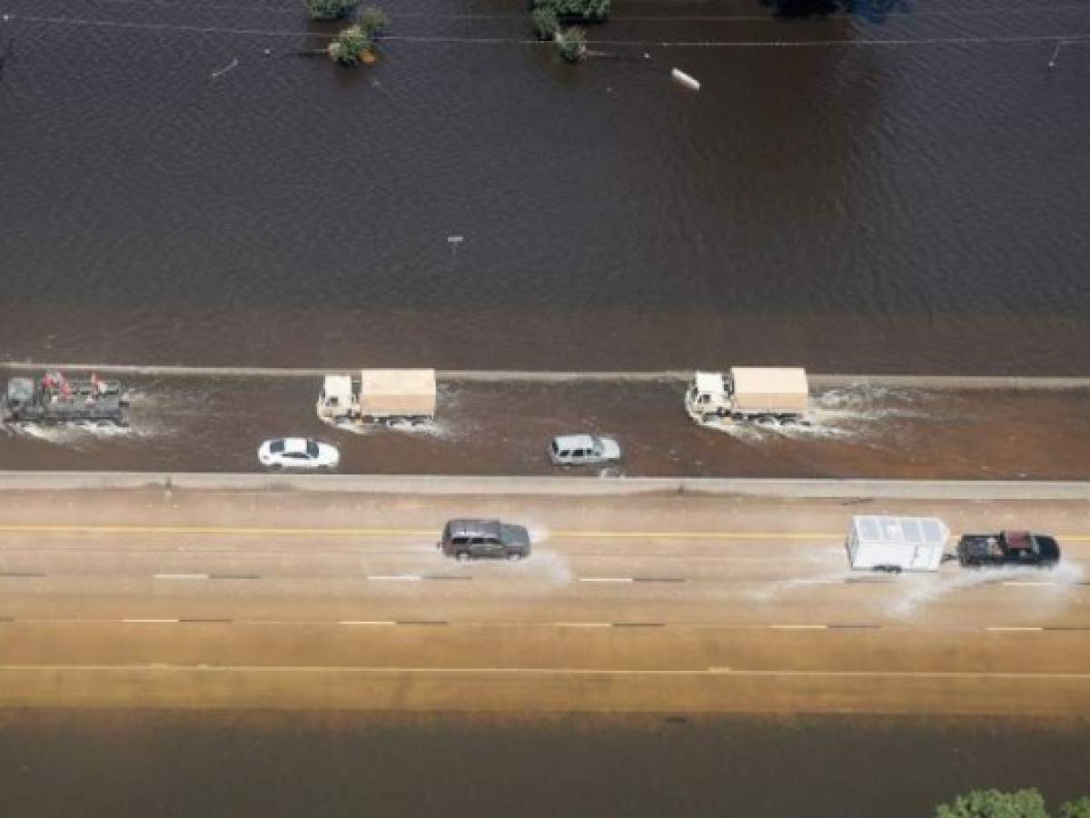 ORANGE, TX - AUGUST 31: Vehicles drive through floodwater after torrential rains pounded Southeast Texas following Hurricane and Tropical Storm Harvey on August 31, 2017 near Orange, Texas. Harvey, which made landfall north of Corpus Christi August 25, has dumped nearly 50 inches of rain in and around areas Houston. Scott Olson/Getty Images/AFP