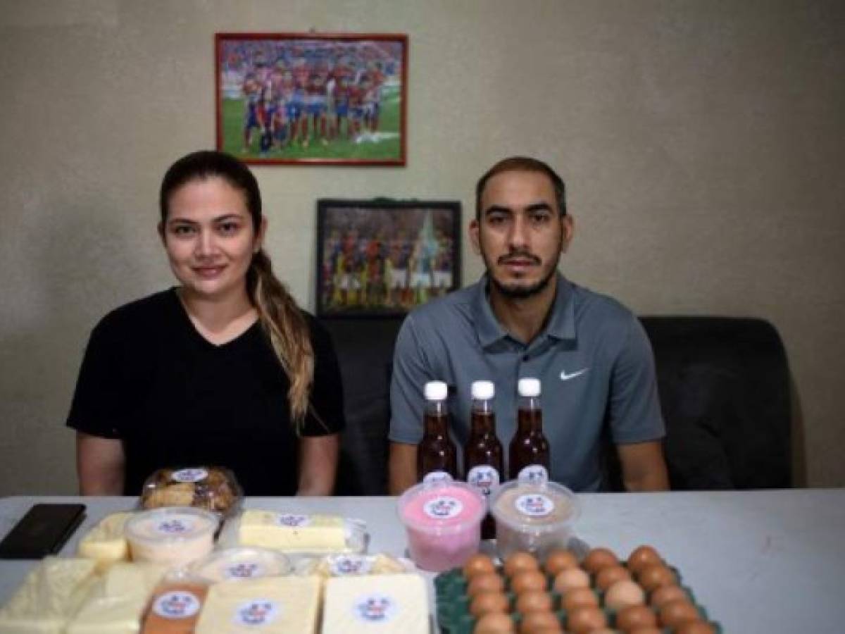 El futbolista salvadoreño Carlos Aparicio y su esposa Danella Nativi, publicista, posan junto a los productos que venden en redes sociales tras perder sus empleos por la crisis del coronavirus. (Foto Yuri CORTEZ / AFP)