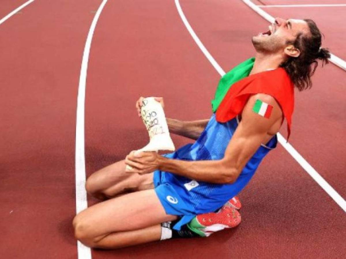 Silver medalist Italy's Gianmarco Tamberi celebrates on the track following the Men's High Jump Final during the Tokyo 2020 Olympic Games at the Olympic Stadium in Tokyo on August 1, 2021. (Photo by Cameron Spencer / POOL / AFP)