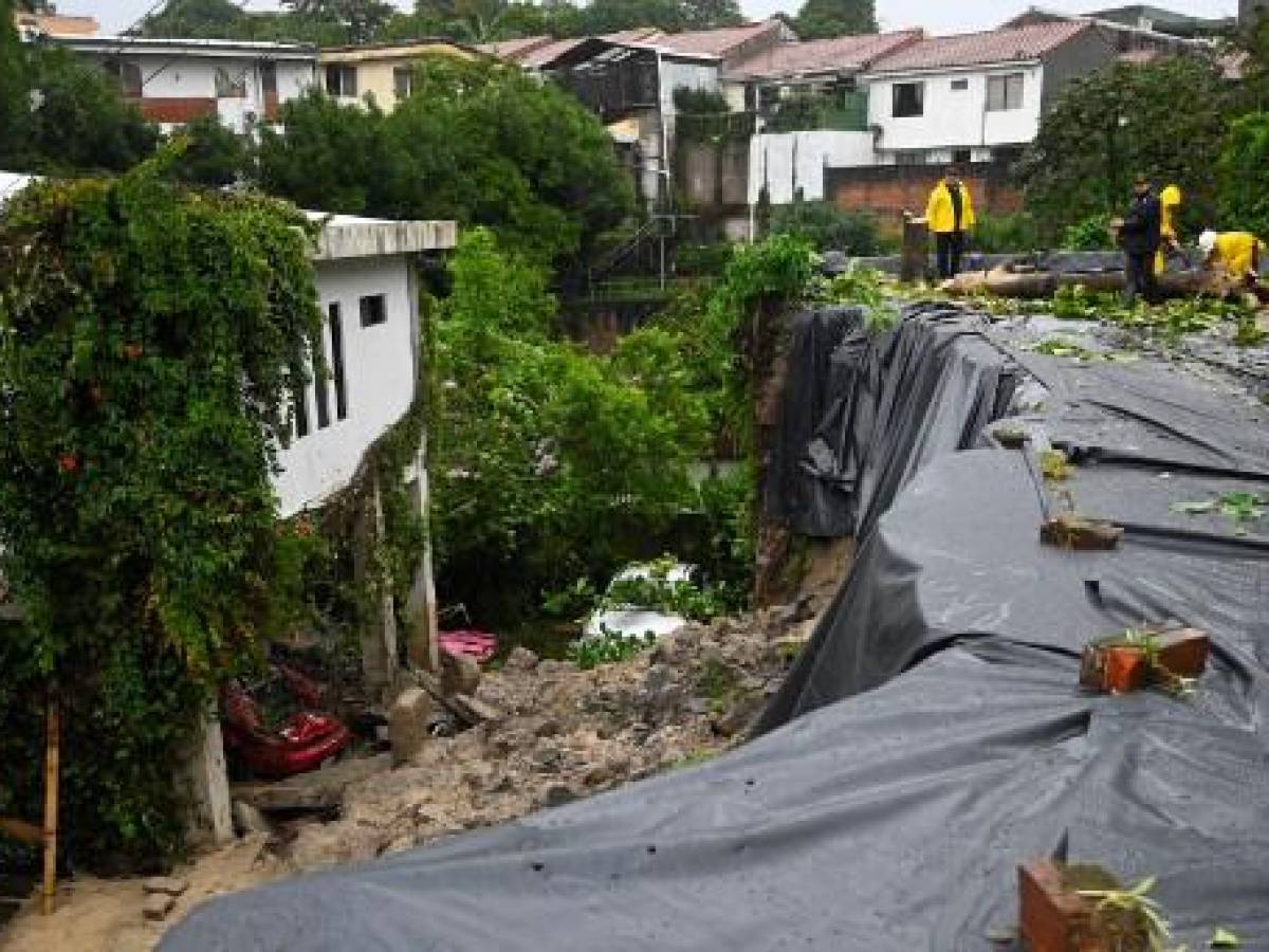 Los rescatistas ayudan a limpiar los escombros tras el paso de la tormenta tropical Julia, en Antiguo Cuscatlán, El Salvador, el 10 de octubre de 2022. (Foto de Marvin RECINOS / AFP)