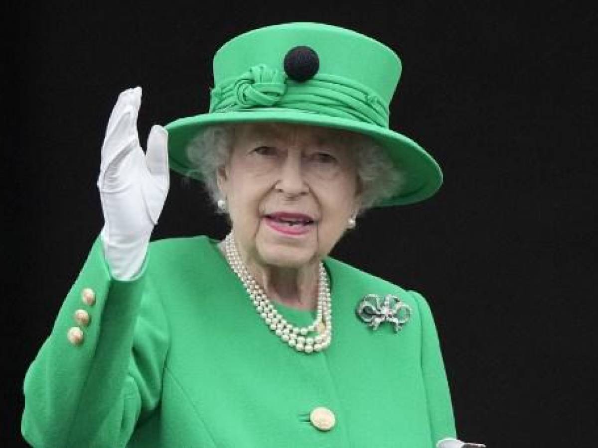 (ARCHIVOS) En esta foto de archivo tomada el 5 de junio de 2022, la reina Isabel II de Gran Bretaña saluda a la multitud desde el balcón del Palacio de Buckingham al final del concurso de platino en Londres como parte de las celebraciones del jubileo de platino de la reina Isabel II. (Foto de Frank Augstein / PISCINA / AFP)