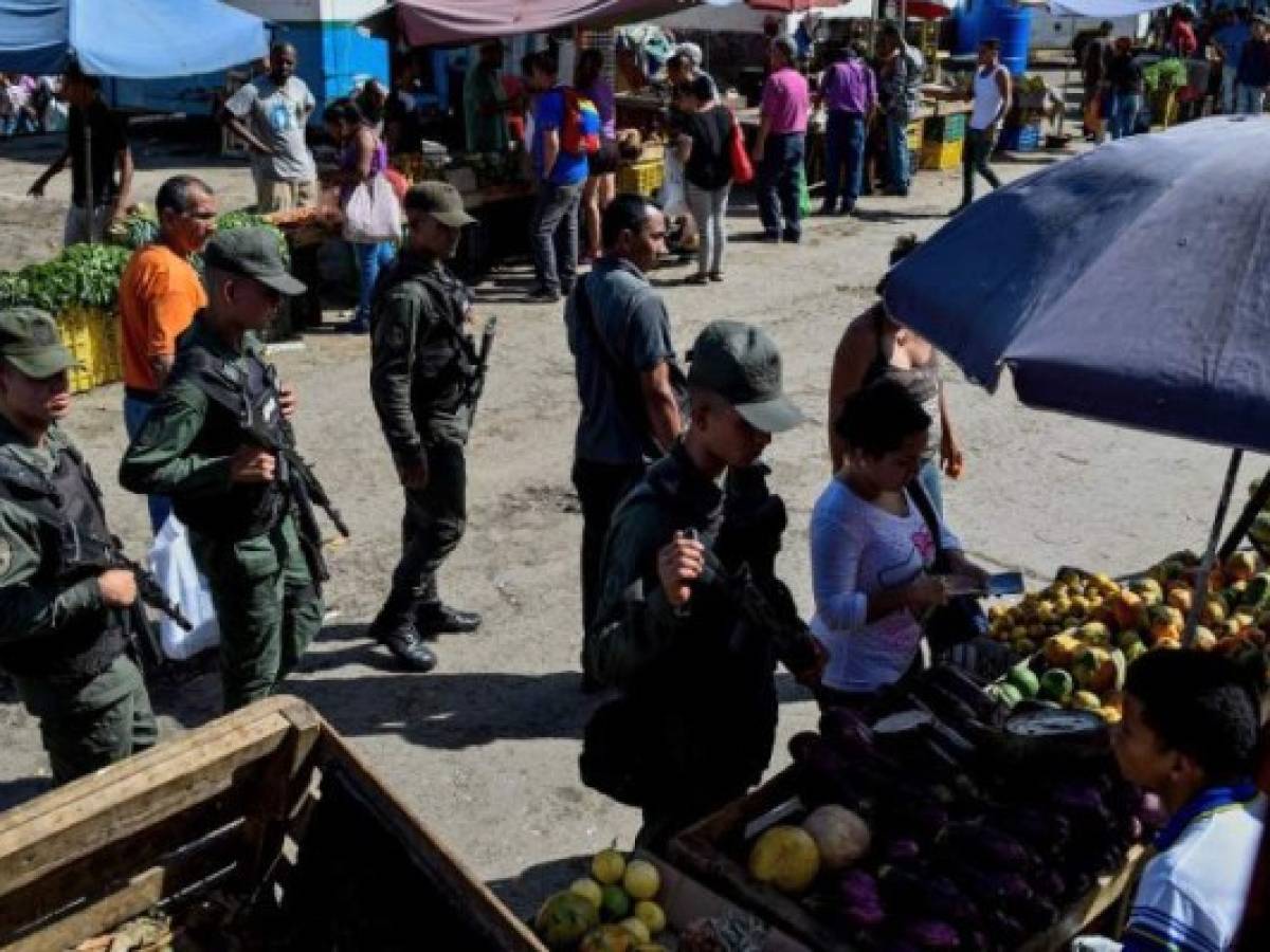 Members of the national guard walk around the municipal market of Coche, a neighbourhood of Caracas, during an inspection to control prices, on June 20, 2018.Venezuelan President Nicolas Maduro ordered the military to take control of popular markets in different states across the country, in the midst of an hyperinflationary spiral and severe shortage of staple foods. / AFP PHOTO / Federico PARRA