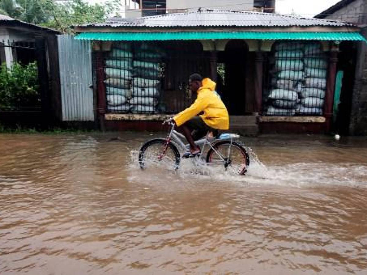 Un residente monta su bicicleta en una calle inundada tras el paso del huracán Julia en el pueblo de Bluefields, en la costa caribeña de Nicaragua el 9 de octubre de 2022. (Foto de OSWALDO RIVAS / AFP)