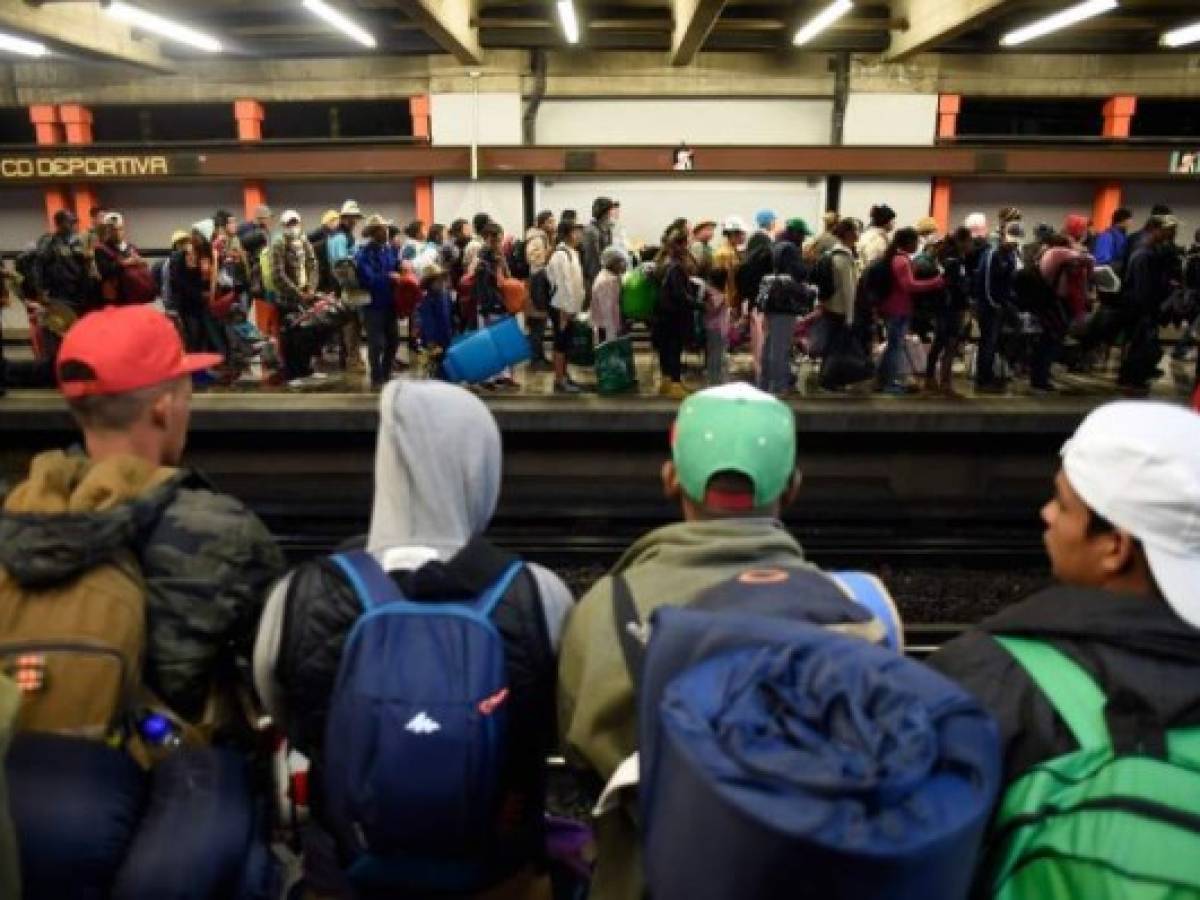 Migrants from poor Central American countries -mostly Hondurans- moving towards the United States in hopes of a better life or to escape violence wait at a metro station in Mexico City on their way north, on November 10, 2018. - The United States embarked Friday on a policy of automatically rejecting asylum claims of people who cross the Mexican border illegally in a bid to deter Central American migrants and force Mexico to handle them. (Photo by Alfredo ESTRELLA / AFP)