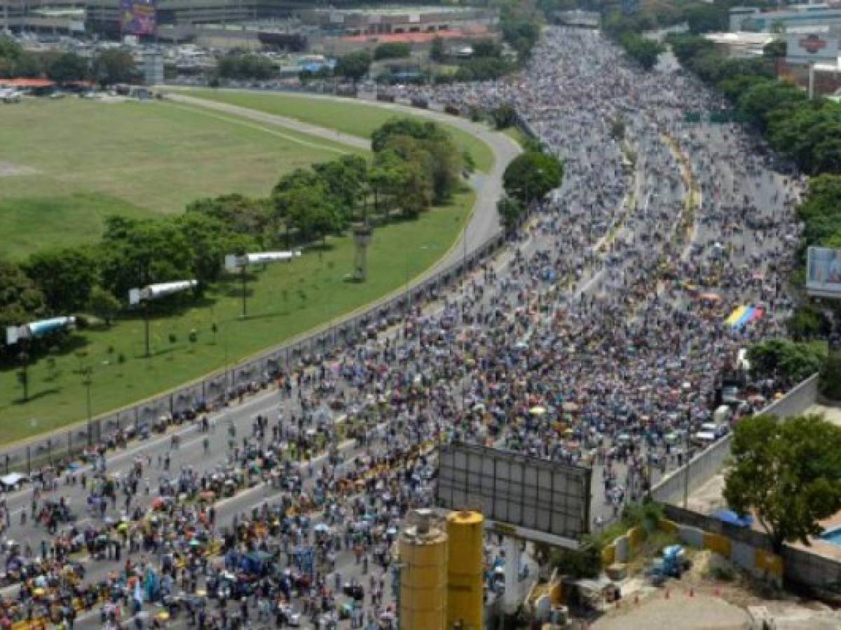 Thousands of Venezuelan opposition activists demonstrate against President Nicolas Maduro in Caracas, on April 24, 2017.Protesters rallied on Monday vowing to block Venezuela's main roads to raise pressure on Maduro after three weeks of deadly unrest that have left 21 people dead. Riot police fired rubber bullets and tear gas to break up one of the first rallies in eastern Caracas early Monday while other groups were gathering elsewhere, the opposition said. / AFP PHOTO / Federico PARRA