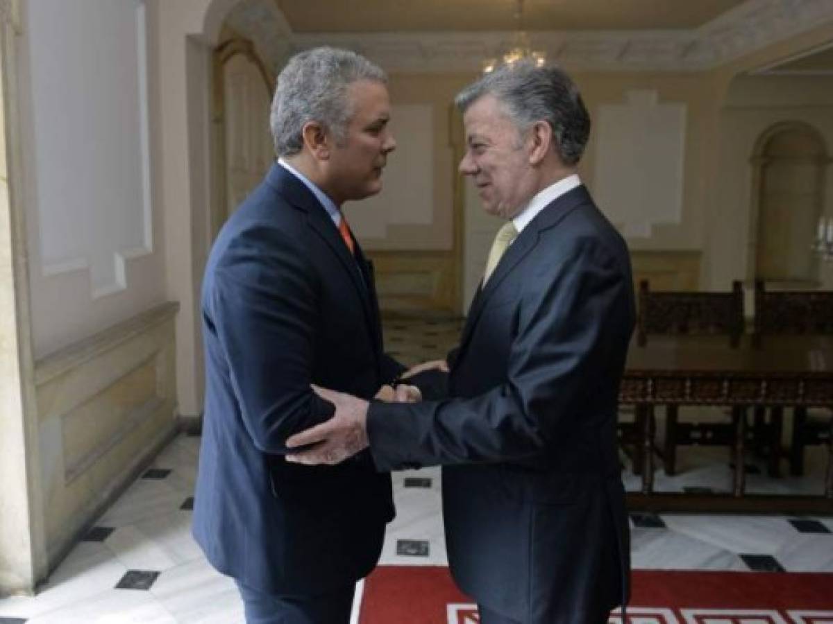 This handout picture released by the Colombian Presidency shows President Juan Manuel Santos (R) receiving Colombian president-elect Ivan Duque at Narino palace in Bogota before holding a meeting on June 21, 2018. / AFP PHOTO / Colombian Presidency / Juan David Tena / RESTRICTED TO EDITORIAL USE - MANDATORY CREDIT 'AFP PHOTO - Colombian Presidency / BYLINE - Juan David TENA' - NO MARKETING NO ADVERTISING CAMPAIGNS - DISTRIBUTED AS A SERVICE TO CLIENTS