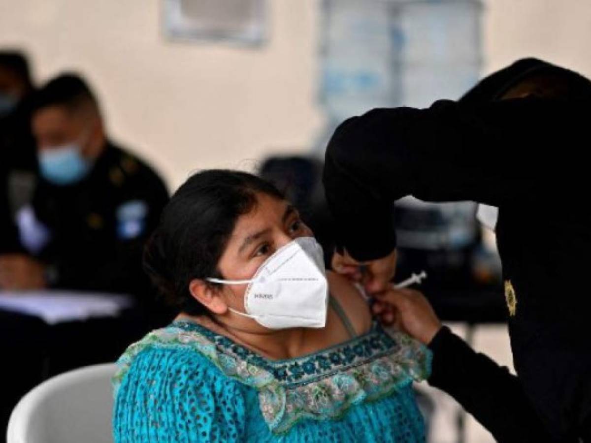 A woman is inoculated with a dose of the AstraZeneca vaccine against COVID-19, at a vaccination center on Constitution Square, in Guatemala City, August 25, 2021, amid a spike in the number of coronavirus cases. (Photo by Johan ORDONEZ / AFP)