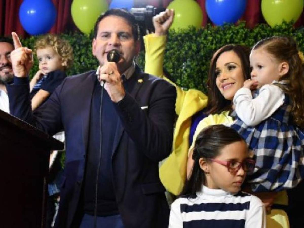 Fabricio Alvarado, presidential candidate of the National Restoration party (PRN), greets supporters next to his wife Laura Moscoa and daugther before delivering a speech during a rally after Costa Rica's presidential election in San Jose, Costa Rica February 4, 2018. / AFP PHOTO / Ezequiel BECERRA