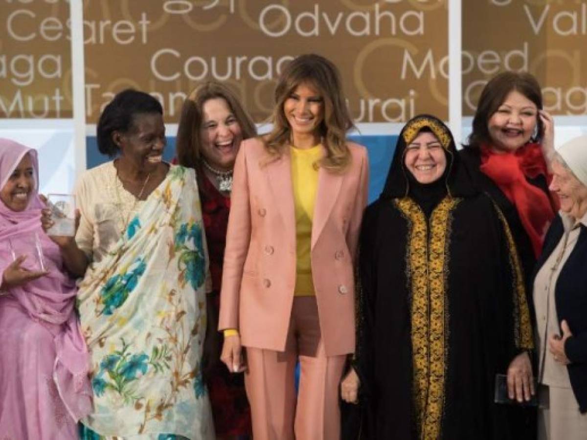US First Lady Melania Trump laughs alongside winners of the 2018 International Women of Courage Award, including L'Malouma Said (L) of, Mauritania, Godelieve Mukasarasi (2nd L) of Rwanda, Dr. Julissa Villanueva (3rd L) of Honduras, Aliyah Khalaf Saleh (3rd) of Iraq, Aiman Umarova (2nd R) of Kazakhstan, and Sister Maria Elena Berini (R) of Italy, during the Award Ceremony at the State Department in Washington, DC, March 23, 2018. / AFP PHOTO / SAUL LOEB