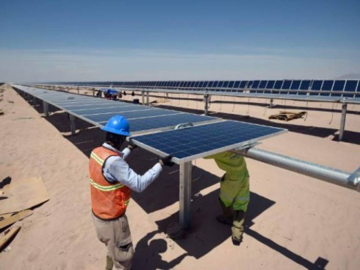(FILES) In this file picture taken on April 20, 2018 workers install new solar panels at the Villanueva photovoltaic (PV) power plant operated by Italian company Enel Green Power in the desert near Villanueva, a town located in the municipality of Viesca, Coahuila State, Mexico.The plant covers an area the size of 40 football fields making it the largest solar plant in the Americas. / AFP PHOTO / Alfredo ESTRELLA
