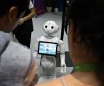 <i>Unos visitantes hablan con el robot 'Pepper' en una imagen de archivo de una feria. EFE/EPA/SEBASTIEN NOGIER</i>