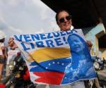 <i>Una mujer sostiene una bandera mientras espera la llegada de la líder opositora y premio nobel de la paz 2025, en Maracay (Venezuela). EFE/ Miguel Gutiérrez</i>