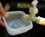 Fotografía de archivo de una persona intenta llenar un recipiente con agua. EFE/ Gustavo Amador