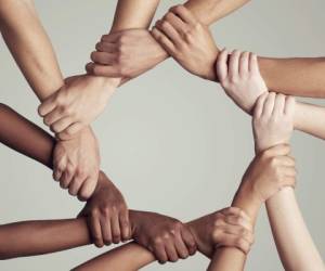 Cropped shot of a diverse group of unidentifiable people holding hands in a circle