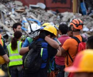 Rescatistas se abrazan tras una alerta de sismo el 23 de septiembre de 2017, en la Ciudad de México. El terremoto derribó 39 edificios, sobre todo, en el área central con viejas construcciones populares donde habitan turistas y visitantes. AFP PHOTO / RONALDO SCHEMIDT