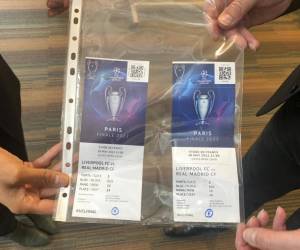 Una entrada falsa y una verdadera de la final de la Champions League son mostradas en la conferencia de prensa el lunes 30 de mayo de 2022 en la final del Estadio de Francia. (AP Photo/Rob Harris)