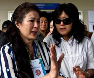 Una familiar de uno de los pasajeros del vuelo QZ8501 de AirAsia, desaparecido sale del centro de crisis instalado en el aeropuerto internacional de Juanda, en Surabaya, Indonesia. (Foto: AFP)