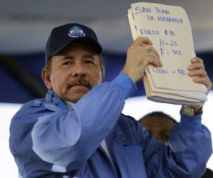 Nicaraguan President Daniel Ortega holds documents with signatures in his support during the commemoration of the 51st anniversary of the Pancasan guerrilla campaign in Managua, on August 29, 2018. Ortega called the UN High Commissioner for Human Rights 'infamous' and 'terror instrument', after it denounced Wednesday systematic human rights violations in the framework of opposition protests in which 300 people were killed. / AFP PHOTO / INTI OCON