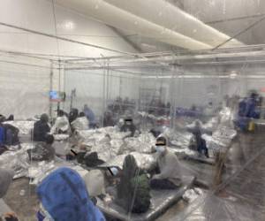 Migrants crowd a room with walls of plastic sheeting at the U.S. Customs and Border Protection temporary processing center in Donna, Texas, U.S. in a recent photograph released March 22, 2021. Office of Congressman Henry Cuellar (TX-28)/Handout via REUTERS ATTENTION EDITORS: FACES OBSCURED AT SOURCE. THIS IMAGE HAS BEEN SUPPLIED BY A THIRD PARTY. TPX IMAGES OF THE DAY