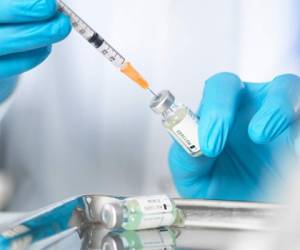 Close up of doctors hands preparing a vaccine to inject patient