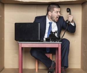 angry businessman at the box office screaming to the telephone handset