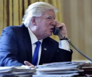 US President Donald Trump speaks on the phone with Russia's President Vladimir Putin from the Oval Office of the White House on January 28, 2017, in Washington, DC. / AFP PHOTO / Mandel Ngan