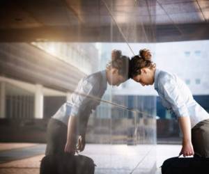 mid adult italian woman banging her head against a wall outside office building. Horizontal shape, copy space